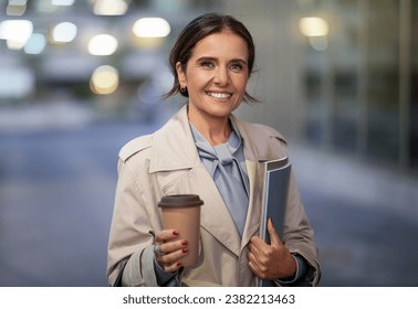 Portrait of attractive brunette middle aged business woman wearing formal outfit posing outdoors, drinking takeaway coffee and smiling at camera. Women in business - Powered by Shutterstock