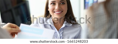 Portrait of attractive businesswoman smiling and looking at biz partner with happiness. People working at important business documents. Teamwork concept