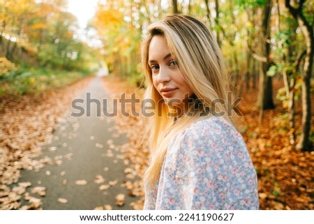 Portrait of attractive caucasian woman posing in the autumn park.