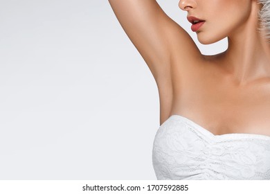 Portrait of attractive Caucasian woman with raised hand. beautiful young girl holds feather in hands and looks at armpit. Smooth clean skin of the face and body. concept care, epilation armpit