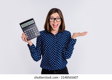 Portrait Of Attractive Cheerful Amazed Girl Holding Calculator Cash Savings Having Fun Isolated Over Grey Pastel Color Background