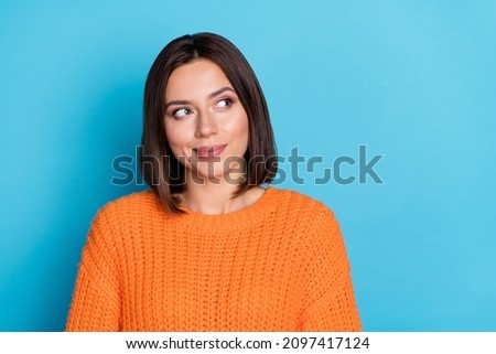 Portrait of attractive cheerful bewildered girl deciding copy empty space isolated over bright blue color background