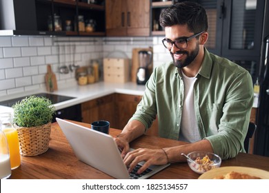 Portrait Of Attractive Cheerful Blogger With Glasses, Using Laptop, Writing New Blog Post