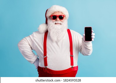 Portrait of attractive cheerful confident white-haired Santa holding in hand device gadget order shop buy wireless payment service isolated bright vivid shine vibrant blue color background - Powered by Shutterstock