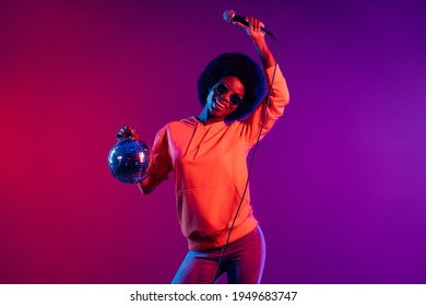 Portrait attractive cheerful dark skin person hold disco ball mic have fun partying isolated colorful background