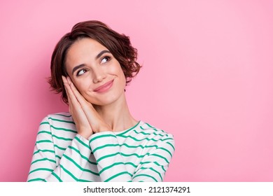 Portrait of attractive cheerful dreamy girl resting enjoying copy space isolated over pink pastel color background