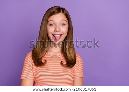 Portrait of attractive cheerful funky brown-haired girl showing tongue good mood isolated over vibrant violet purple color background
