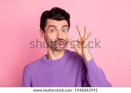 Portrait of attractive cheerful funny guy pretending like smoking cigarette isolated over pink pastel color background