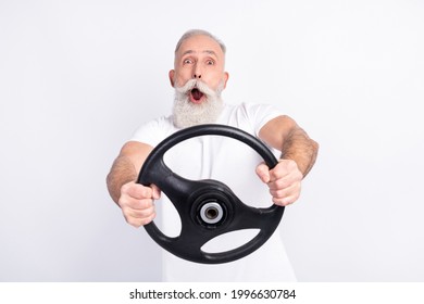 Portrait of attractive cheerful funny man holding in hands steering wheel riding having fun isolated over light grey color background