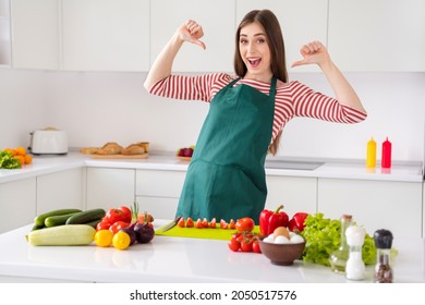 Portrait of attractive cheerful girl cooking tasty fresh dish dinner pointing at herself at home light white kitchen indoors