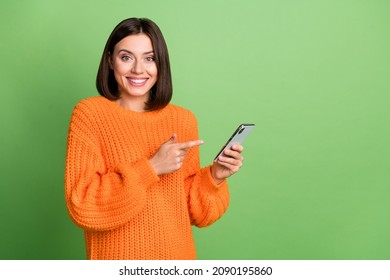Portrait of attractive cheerful girl demonstrating using device post copy space isolated over bright green color background - Shutterstock ID 2090195860