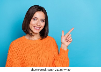 Porträt eines attraktiven, fröhlichen Mädchens, das einen leeren Raum demonstriert und Werbung einzeln auf hellblauem Hintergrund