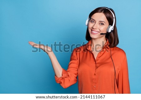 Portrait of attractive cheerful girl help desk service specialist holding copy space isolated over bright blue color background