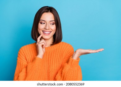 Portrait of attractive cheerful girl holding on palm copy space choosing idea isolated over bright blue color background