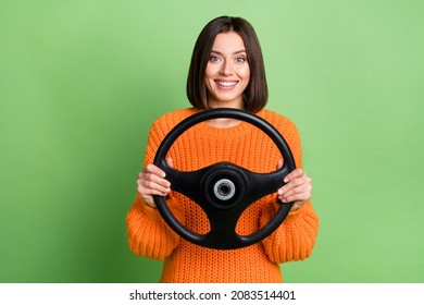 Retrato de una alegre y atractiva niña que sostiene el volante de la dirección camino de viaje aislado sobre un fondo de color verde brillante