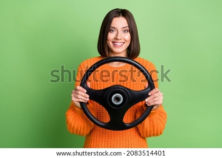 Portrait of attractive cheerful girl holding steering wheel traveling journey road isolated over bright green color background