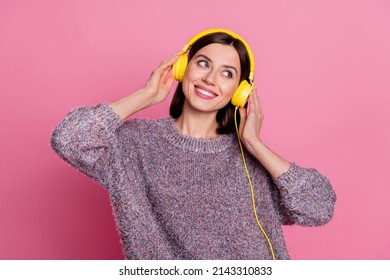 Portrait of attractive cheerful girl listening song enjoying rock roll different single isolated over pink pastel color background