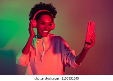 Portrait attractive cheerful girl listening hit playlist pop single isolated over bright multicolor light gradient color background