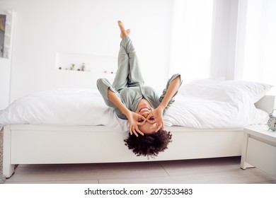 Portrait of attractive cheerful girl lying in bed having fun showing ok-sign like glasses fooling at light home house indoors