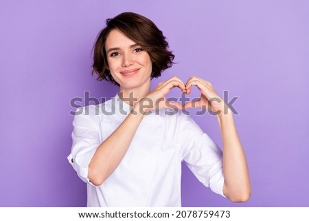 Portrait of attractive cheerful girl showing heart shape amour affection isolated over bright violet purple color background