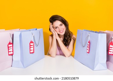 Portrait of attractive cheerful girl sitting with new clothes enjoying offer isolated over bright yellow color background - Shutterstock ID 2180510879