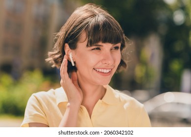 Portrait of attractive cheerful girl talking on cell roaming using device gadget handsfree on fresh air outdoors