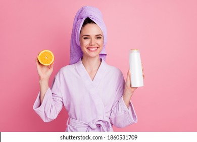 Portrait Of Attractive Cheerful Girl Wearing Towel Turban On Hair Holding In Hand Slice Orange Keratin Lotion Isolated On Pink Pastel Color Background