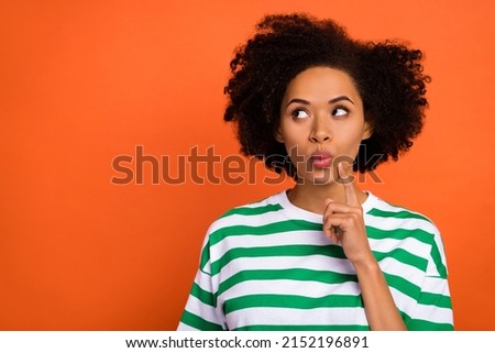 Portrait of attractive cheerful girly bewildered girl overthinking copy space isolated over bright orange color background