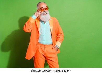 Portrait of attractive cheerful grey-haired man posing touching mustache copy space isolated over bright green color background