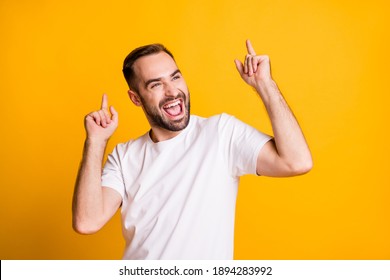 Portrait of attractive cheerful guy dancing having fun rest isolated over bright yellow color background