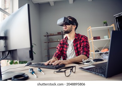 Portrait of attractive cheerful guy wearing goggles headset playing video game having fun at work place station indoors