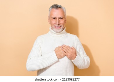 Portrait Of Attractive Cheerful Kind Grey-haired Man Touching Heart Feelings Isolated Over Beige Pastel Color Background