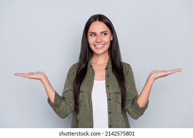 Portrait of attractive cheerful long-haired woman holding copy space on palms ad isolated over grey pastel color background - Shutterstock ID 2142575801