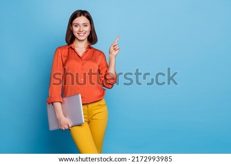 Portrait of attractive cheerful skilled girl holding laptop showing copy empty space ad isolated over bright blue color background