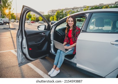 Portrait of attractive cheerful skilled wavy-haired girl sitting in auto writing email service order on parking outdoors - Shutterstock ID 2154593887