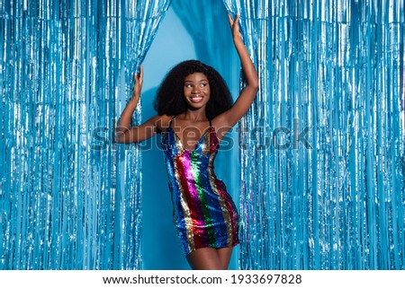 Portrait of attractive cheerful slim girl celebrity posing having fun clubbing rest isolated over blue tinsel curtain background