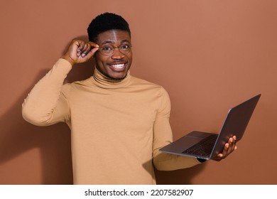 Portrait Of Attractive Cheerful Smart Clever Guy Using Laptop Developing Startup Touching Specs Isolated Over Brown Color Background