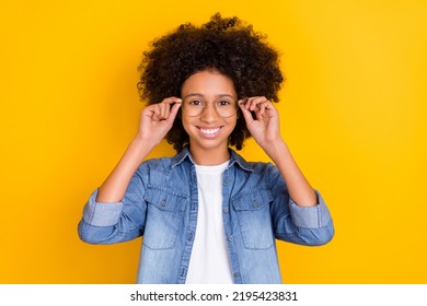 Portrait Of Attractive Cheerful Teen Girl Nerd Touching Eyewear Isolated Over Bright Yellow Color Background