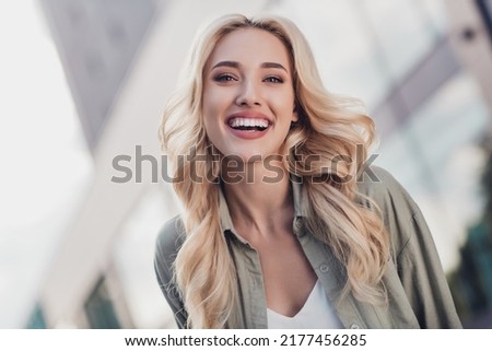 Portrait of attractive cheerful wavy haired girl having fun strolling on fresh air weekend outside