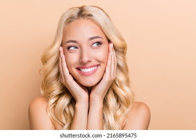 Portrait of attractive cheerful wavy-haired girl touching silky skin foundation copy space isolated over beige pastel color background