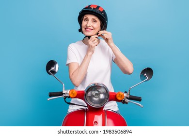 Portrait Of Attractive Cheerful Woman Fixing Helmet Riding Motor Bike Isolated Over Bright Blue Color Background