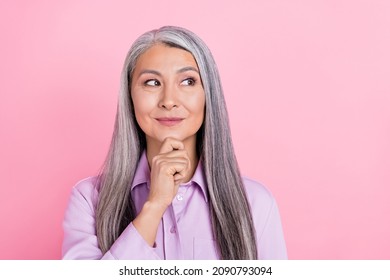 Portrait of attractive cheery curious gray-haired woman overthinking copy space isolated over pink pastel color background