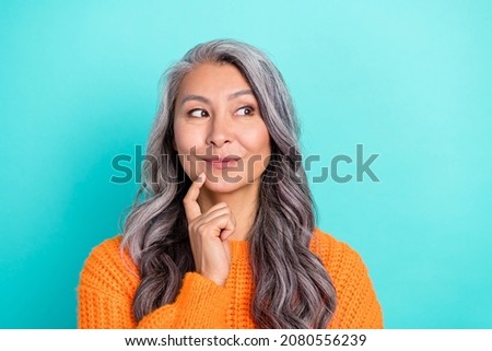 Portrait of attractive cheery curious grey-haired woman thinking touching chin isolated over bright teal turquoise color background