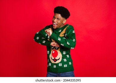 Portrait of attractive cool cheerful guy wearing ugly jumper having fun dancing good mood rest isolated over bright red color background