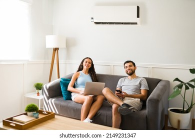 Portrait of an attractive couple working at home together while enjoying the air conditioning