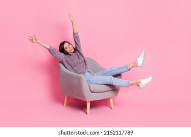 Portrait of attractive cute cheerful girl sitting in armchair rising hands up isolated over pink pastel color background - Shutterstock ID 2152117789