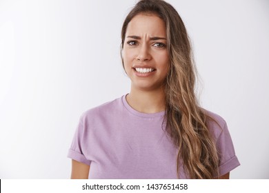 Portrait attractive dissatisfied grimacing woman hearing disgusting story frowning clenching teeth aversion, reluctance, friend tell displeasing gross story details, disliking, feeling awkward