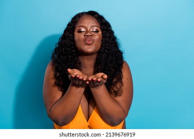 Portrait of attractive dreamy amorous fat woman sending air kiss cupid date isolated over bright blue color background.