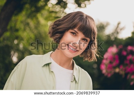Portrait of attractive dreamy cheerful brown-haired girl spending sunny day at blooming garden fresh air outdoors