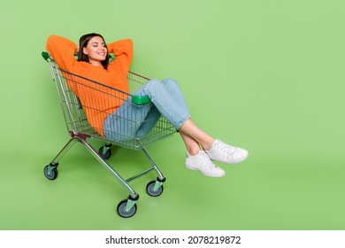 Portrait of attractive dreamy cheerful girl riding cart lying resting silence isolated over bright green color background - Shutterstock ID 2078219872